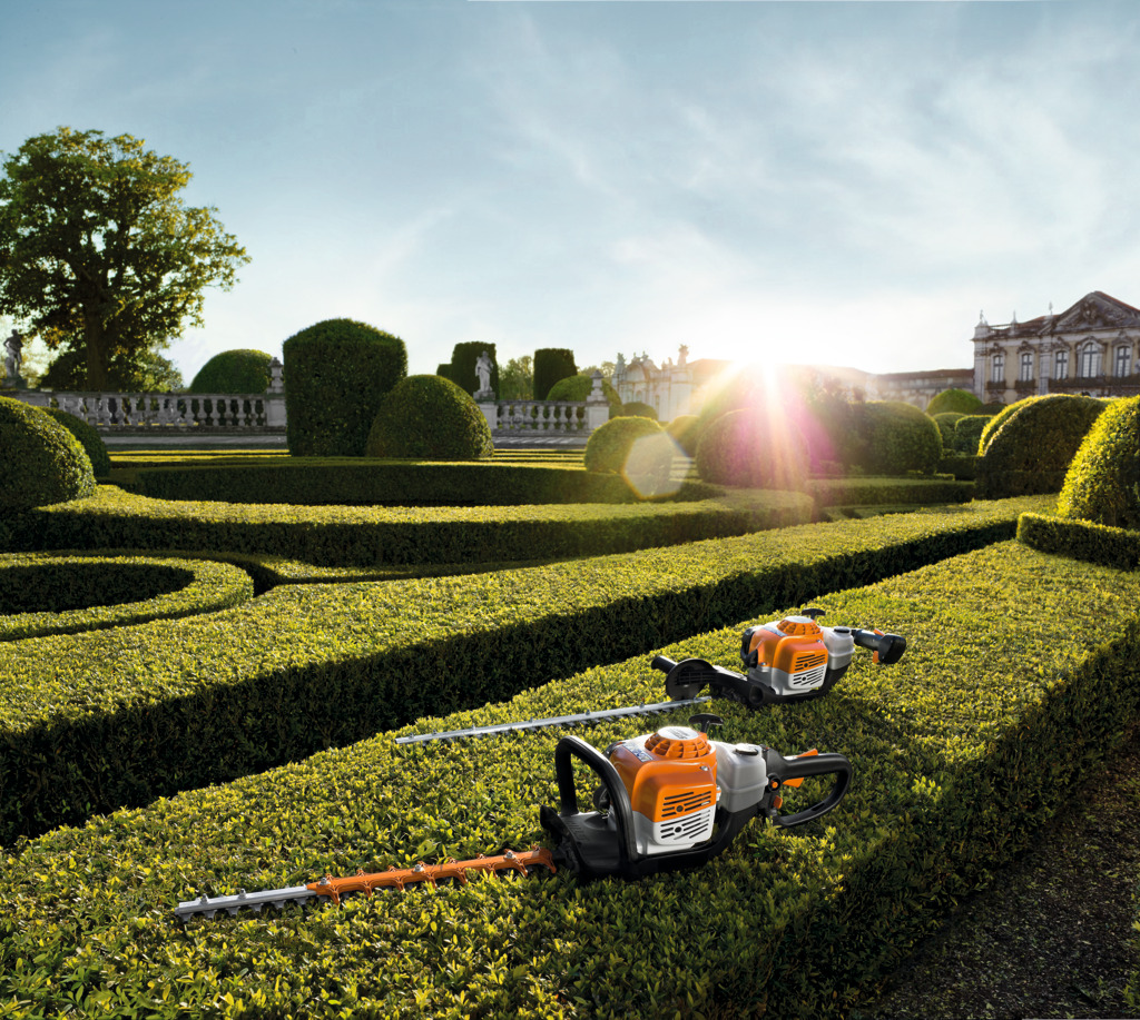Two STIHL Hedge Trimmers on a small hedge overlooking a garden