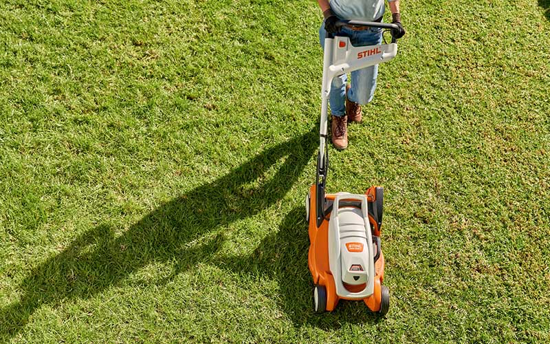 Close up of a woman using the STIHL RMA 339 C Battery lawnmower to mow her lawn